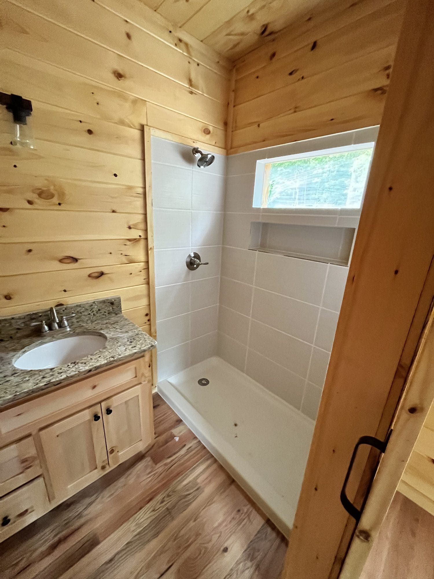 Bathroom with pine walls, vanity and white shower