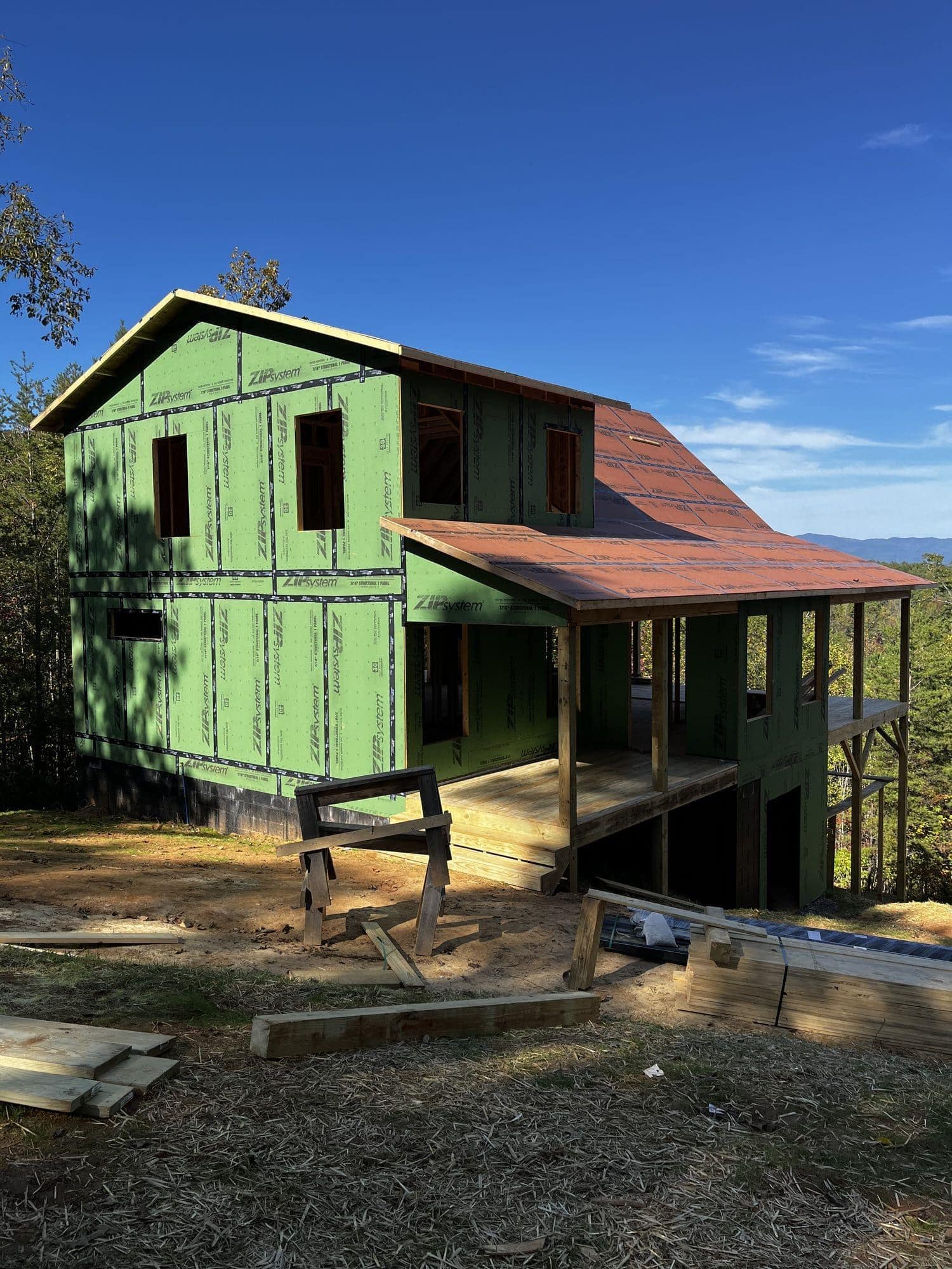 Two-story home with green sheathing and porch framing