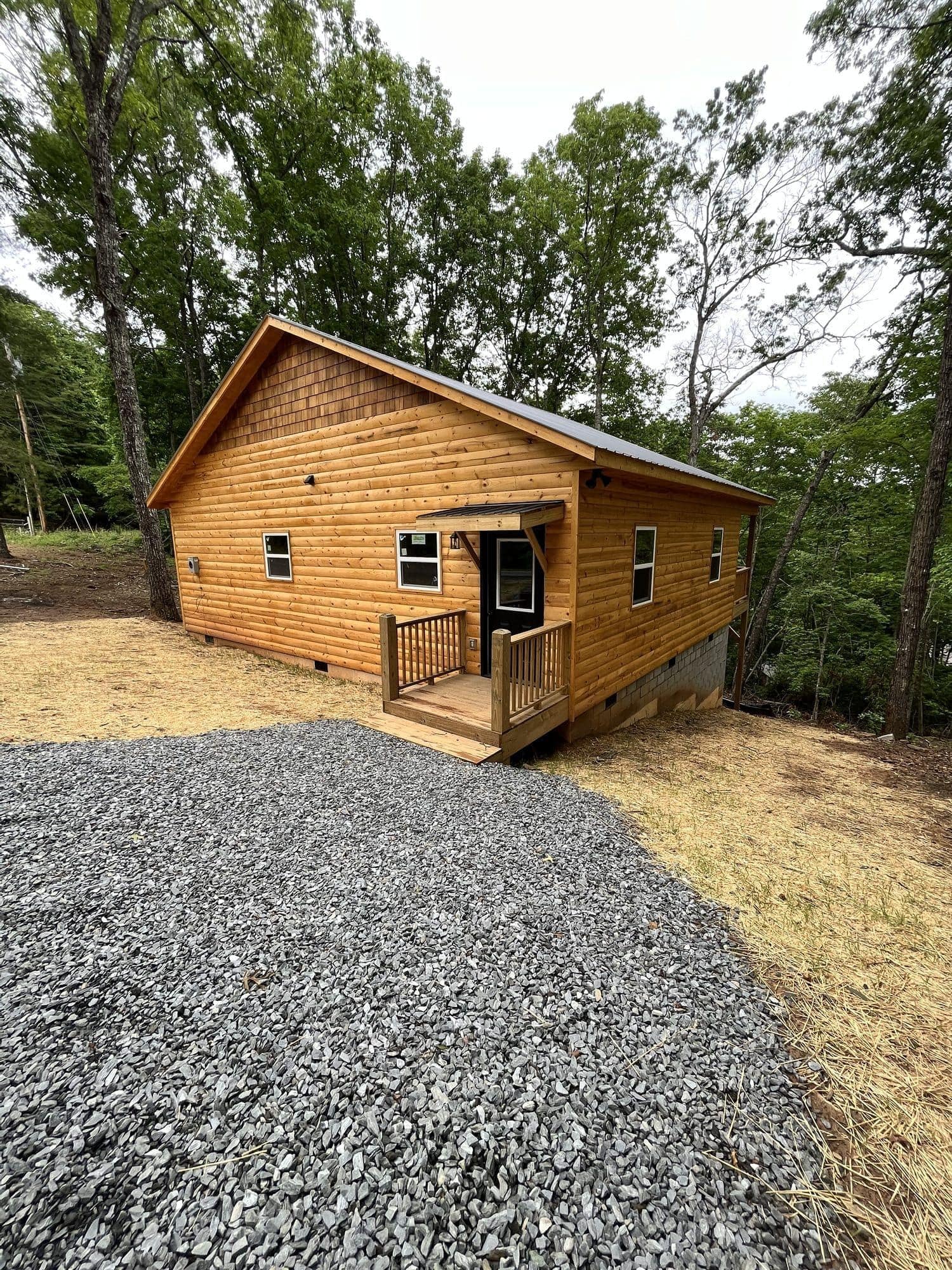 Small wood cabin with front porch on a gravel pad