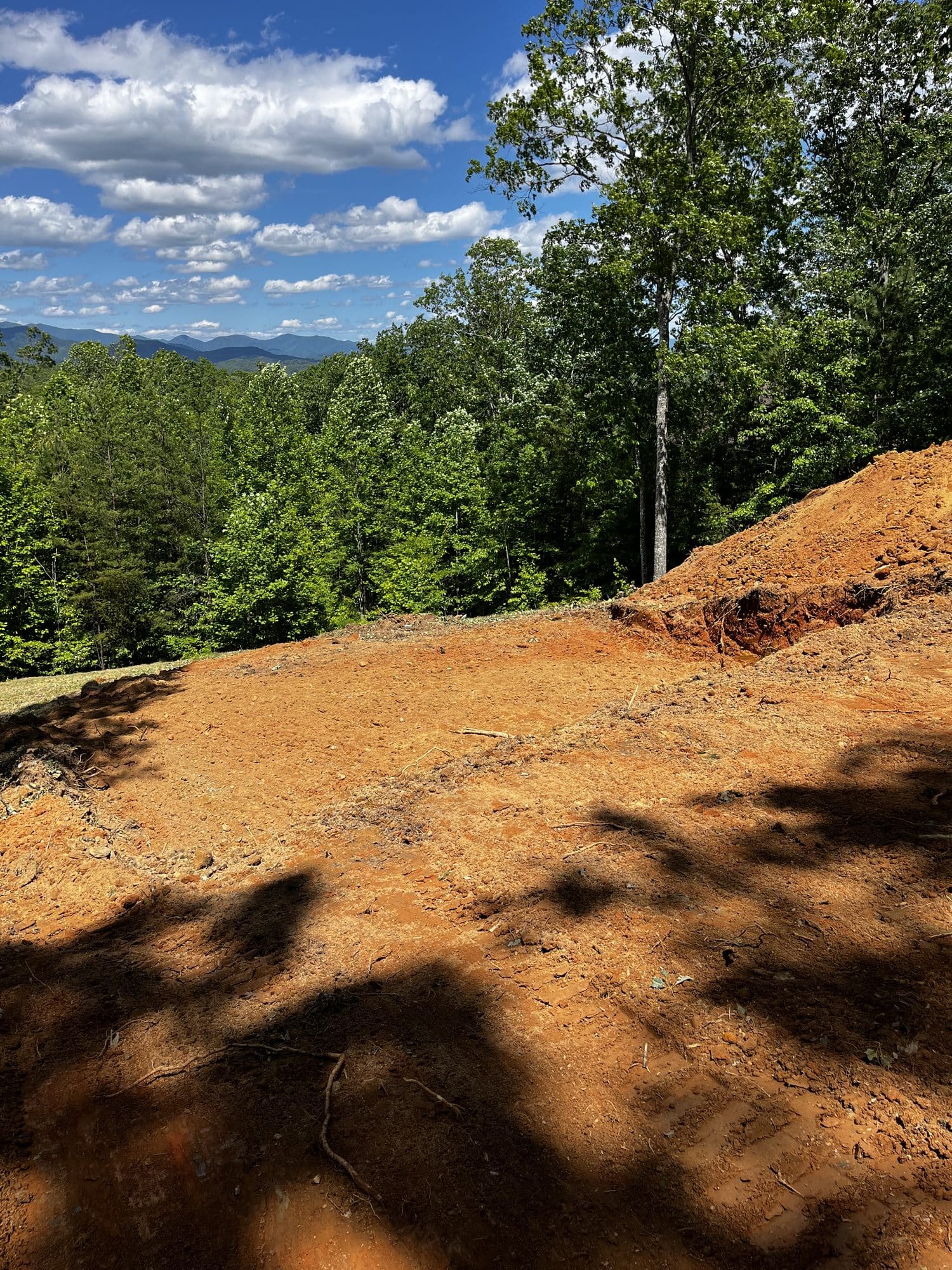 Graded red clay pad with distant mountains behind