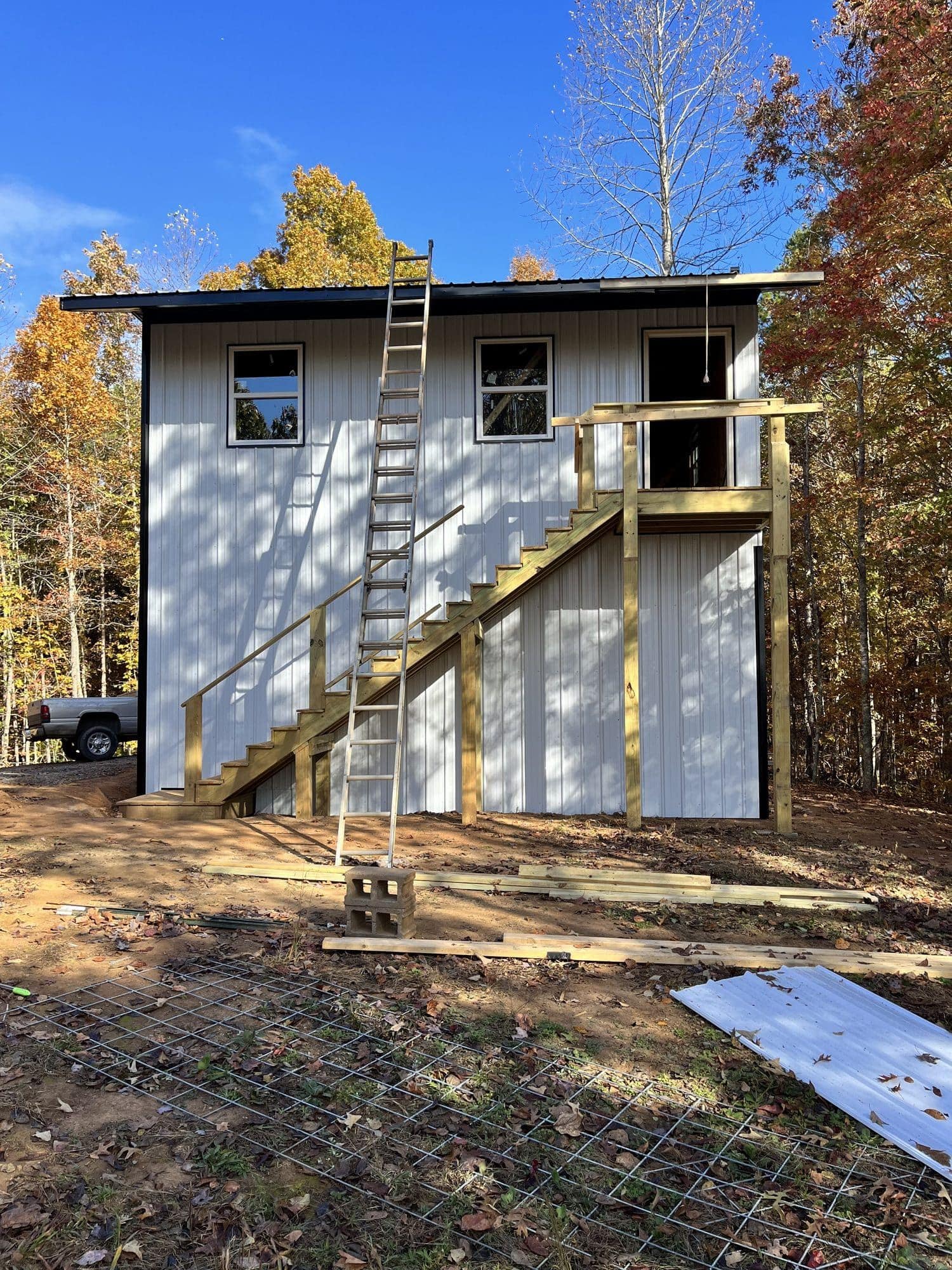 Side of two-story metal-sided building with wood stairs